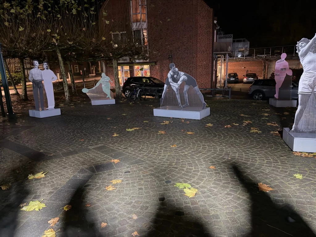 Foto der Ausstellung. Aufsteller verschiedener Sportler auf dem Marktplatz in Telgte.